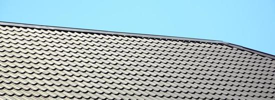 um fragmento de um telhado de uma telha de metal de cor vermelha escura. coberturas de qualidade foto