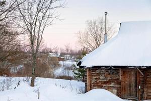 casa de madeira coberta de neve no país foto