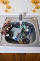 hardware na pia da cozinha sob o conceito metafórico de limpeza de computador de fluxo de água foto