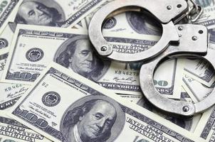 algemas da polícia estão em muitas notas de dólar. o conceito de posse ilegal de dinheiro, transações ilegais com dólares americanos. crime econômico foto