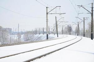 paisagem ferroviária de inverno, trilhos ferroviários no país industrial coberto de neve foto