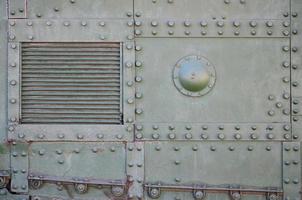 a textura da parede do tanque, feita de metal e reforçada com uma infinidade de parafusos e rebites. imagens da cobertura de um veículo de combate da segunda guerra mundial foto