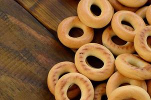 muitos bagels amarelos frescos estão na superfície da velha madeira escura. um tipo popular de produtos de farinha. uma das guloseimas tradicionais russas para o chá foto