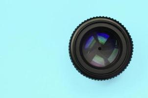 a lente da câmera com uma abertura fechada está no fundo da textura do papel de cor azul pastel de moda foto