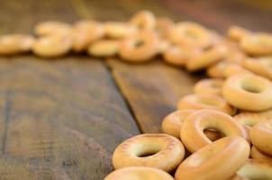 muitos bagels amarelos frescos estão na superfície da velha madeira escura. um tipo popular de produtos de farinha. uma das guloseimas tradicionais russas para o chá foto