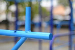 barras esportivas em azul no fundo de um campo de esportes de rua para treinamento de atletismo. equipamento de ginástica esportiva ao ar livre. foto macro com foco seletivo e fundo extremamente desfocado