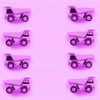 muitos pequenos caminhões de brinquedo roxo sobre fundo de textura de papel de cor roxa pastel de moda foto