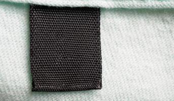 etiqueta de roupas de lavanderia em branco preta no fundo da camisa de algodão foto