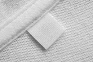 etiqueta de roupas de lavanderia em branco em branco no fundo da camisa de algodão foto