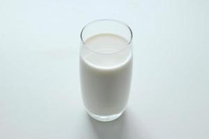 um copo de leite no fundo branco. foto