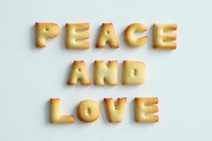 uma inscrição dos biscoitos no fundo branco. texto - paz e amor. foto