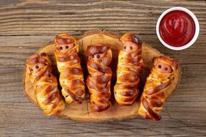 múmias de salsicha assustadoras em massa para festa infantil. comida louca e engraçada de halloween para crianças foto