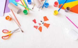 passo 2. ideia de artesanato diy fácil de férias para crianças. bebê de brinquedo de tubo de rolo de papel higiênico em um fundo branco com papel colorido .. decoração criativa de páscoa ecologicamente correta foto