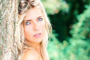 retrato de uma linda loira com olhos azuis na natureza foto