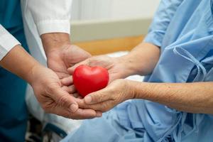 médico dá coração vermelho a paciente idosa ou idosa asiática, conceito médico forte e saudável foto