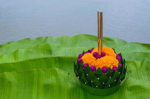 folha de bananeira krathong que tem 3 incensos e vela decora com flores para a lua cheia da tailândia ou loy krathong festival coloca folhas de bananeira verdes. foto