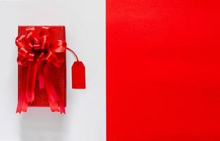 caixa de natal vermelha com fita de laço vermelho e preço em fundo branco e vermelho. conceito de sexta-feira negra e cyber segunda-feira. foto