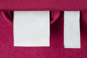 etiqueta de roupas de lavanderia branca em branco no fundo de textura de tecido vermelho foto