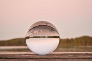 bola de vidro em um cais de madeira em um lago sueco à noite. natureza escandinavia foto