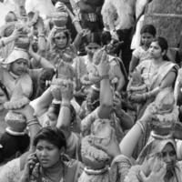 delhi, índia, 03 de abril de 2022 - mulheres com kalash na cabeça durante o templo jagannath mangal kalash yatra, devotos hindus indianos carregam potes de barro contendo água sagrada com coco no topo-preto e branco foto