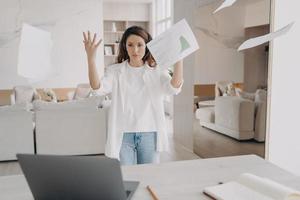 treinador de negócios discute projeto de trabalho por videochamada no laptop, fala com o público, vomitando papéis foto