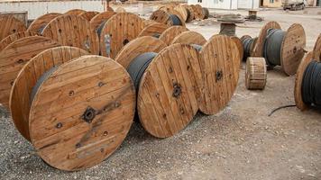 um close de grandes bobinas de madeira industriais com cabo em um canteiro de obras foto