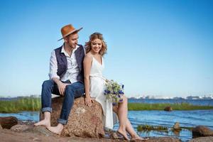 casal feliz na praia com um buquê de flores foto