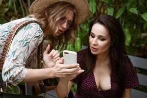 duas amigas no parque olhando para o telefone foto