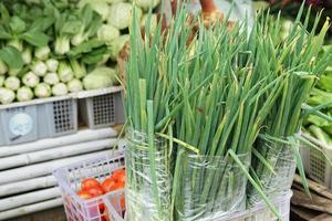 alho-poró fresco e saudável em plástico para venda em mercados tradicionais com fundo de legumes embaçado foto