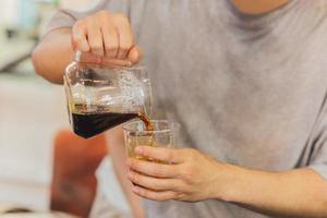 barista derramando café em copos para viagem na cafeteria. foto