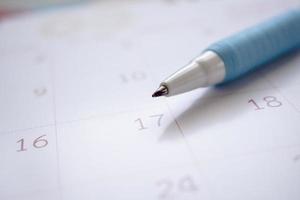 página do calendário com caneta fechar conceito de reunião de planejamento de negócios de fundo foto