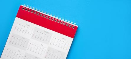página de calendário no conceito de reunião de compromisso de planejamento de negócios de fundo azul foto