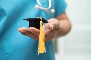 estudo de médico asiático aprende com chapéu de graduação na enfermaria do hospital, conceito de medicina de educação de gênio brilhante inteligente. foto