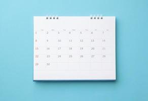 calendário de mesa no conceito de reunião de compromisso de planejamento de negócios de fundo azul foto