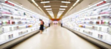 corredor do supermercado com produtos lácteos na geladeira desfocar o fundo foto