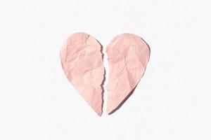 coração partido feito de papel amassado rosa isolado no fundo branco foto