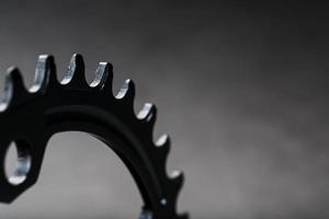 uma estrela de condução de bicicleta preta com engrenagens repetidas contrastantes em um fundo escuro foto