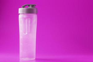 garrafa de smoothie de esportes no fundo rosa, vazio. foto