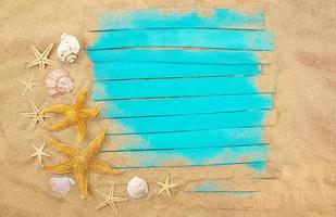 placas de madeira azuis com estrelas do mar, conchas na areia. quadro de verão. conceito de férias, mar, viagens. espaço de cópia foto