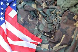 bandeira dos estados unidos da américa e jaqueta de uniforme militar dobrada. bandeira de fundo conceitual de símbolos militares para feriados patrióticos americanos foto