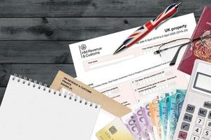 formulário fiscal inglês sa105 uk propriedade da hm Revenue and Customs está na mesa com itens de escritório. hmrc papelada e processo de pagamento de impostos no reino unido foto