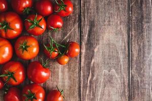 tomates em fundo de madeira, moldura de frutas de tomate vermelho recém-colhidas, fundo de cozinha, copie o espaço foto