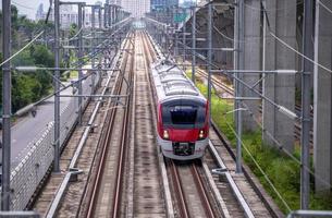 o trem elétrico dirige em movimento de alta velocidade da estação com passageiros e carga para o destino da estação é um conceito moderno de transporte com fundo de céu de luz solar. foto