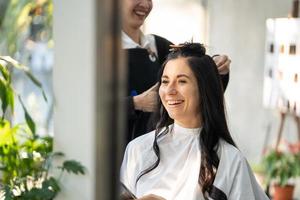 mulheres caucasianas com cabelo elegante enquanto cortam o cabelo e usam máscara facial cirúrgica enquanto estilizam o cabelo para o cliente. ocupação profissional, serviço de beleza e moda novo normal foto