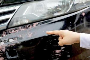 carro pára-choques preto riscado com danos profundos na pintura. foto