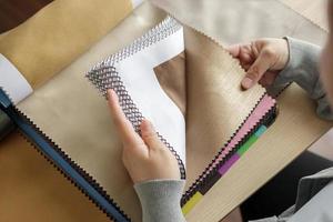 designer feminino com amostras de cores de tecido escolhendo têxteis para cortinas foto