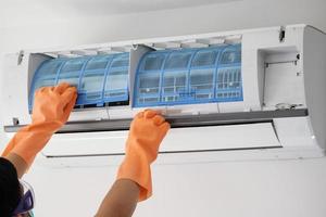 homem asiático mão segure o conceito de limpeza de filtro de ar condicionado foto
