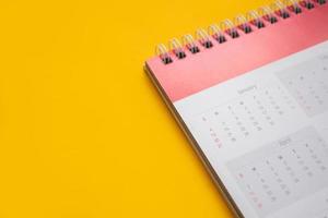página do calendário no conceito de reunião de compromisso de planejamento de negócios de fundo amarelo foto