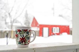 relaxando e bebendo café ou chá, as xícaras de café em um dia de neve, na varanda. conceito de relaxamento. fundo desfocado de lindo. foto