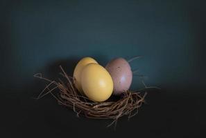 três ovos de páscoa em uma cesta foto